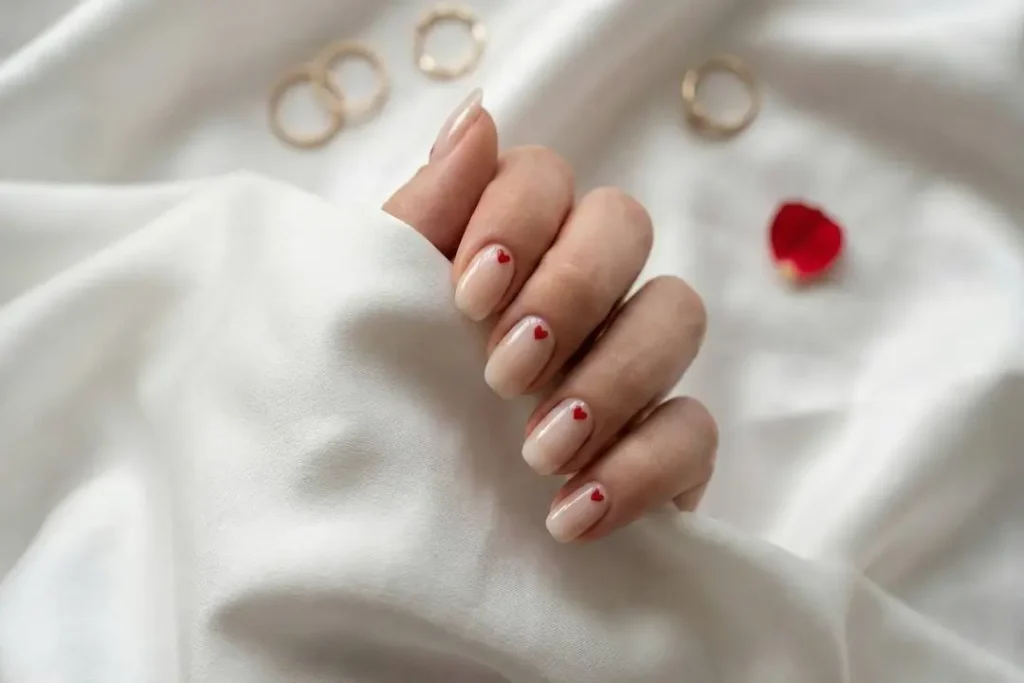 Minimalist valentines nails trend 2026 featuring micro hearts on nude base.