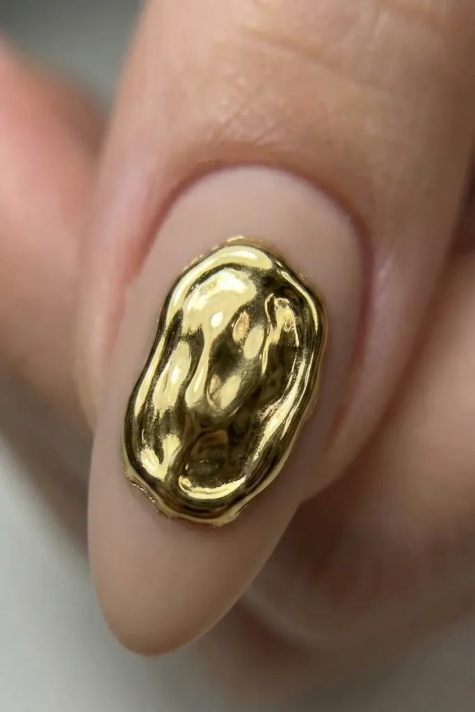 3D gold molten chrome nail art detail on matte base.