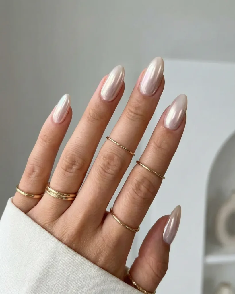 Trendy soft almond nail shape with glazed chrome finish, elongating the fingers.