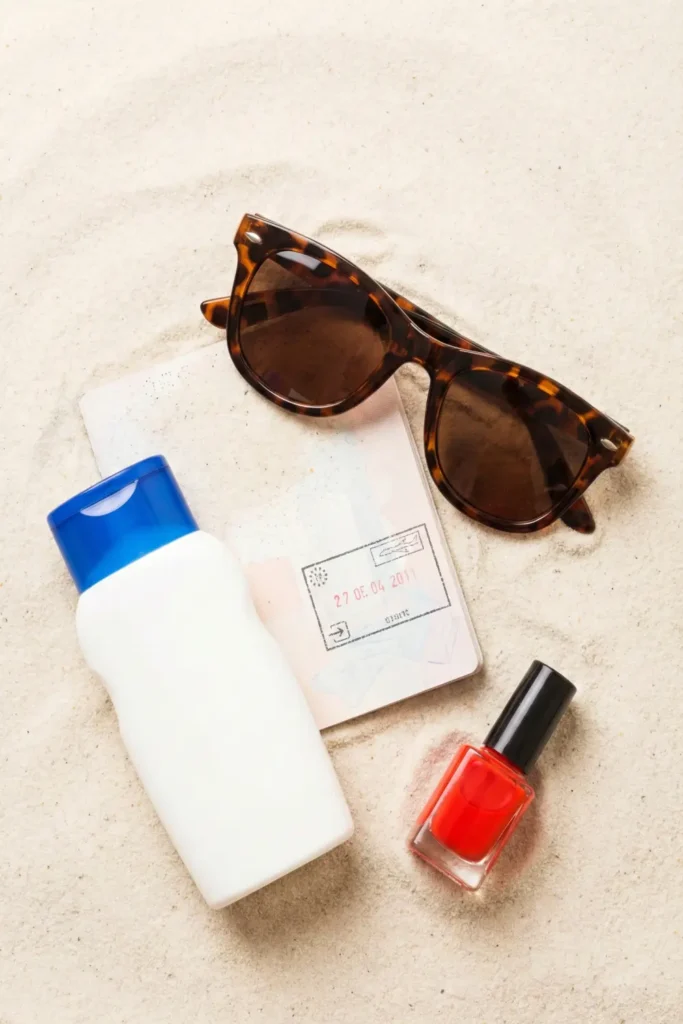 Summer travel essentials with red nail polish.